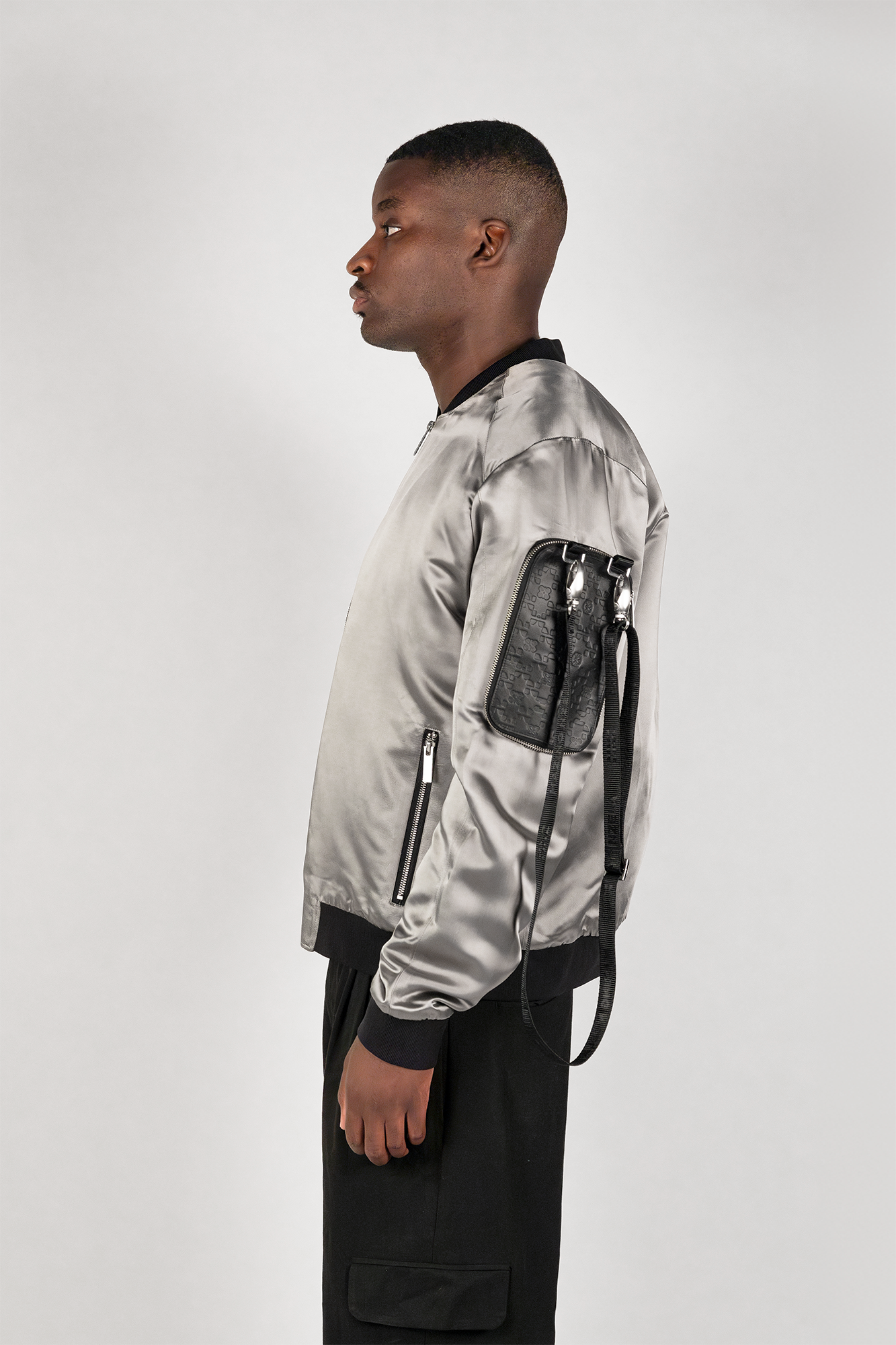Men's bomber jacket with 3D cargo pockets, convertible crossbody bag, modular streetwear design, versatile and functional.