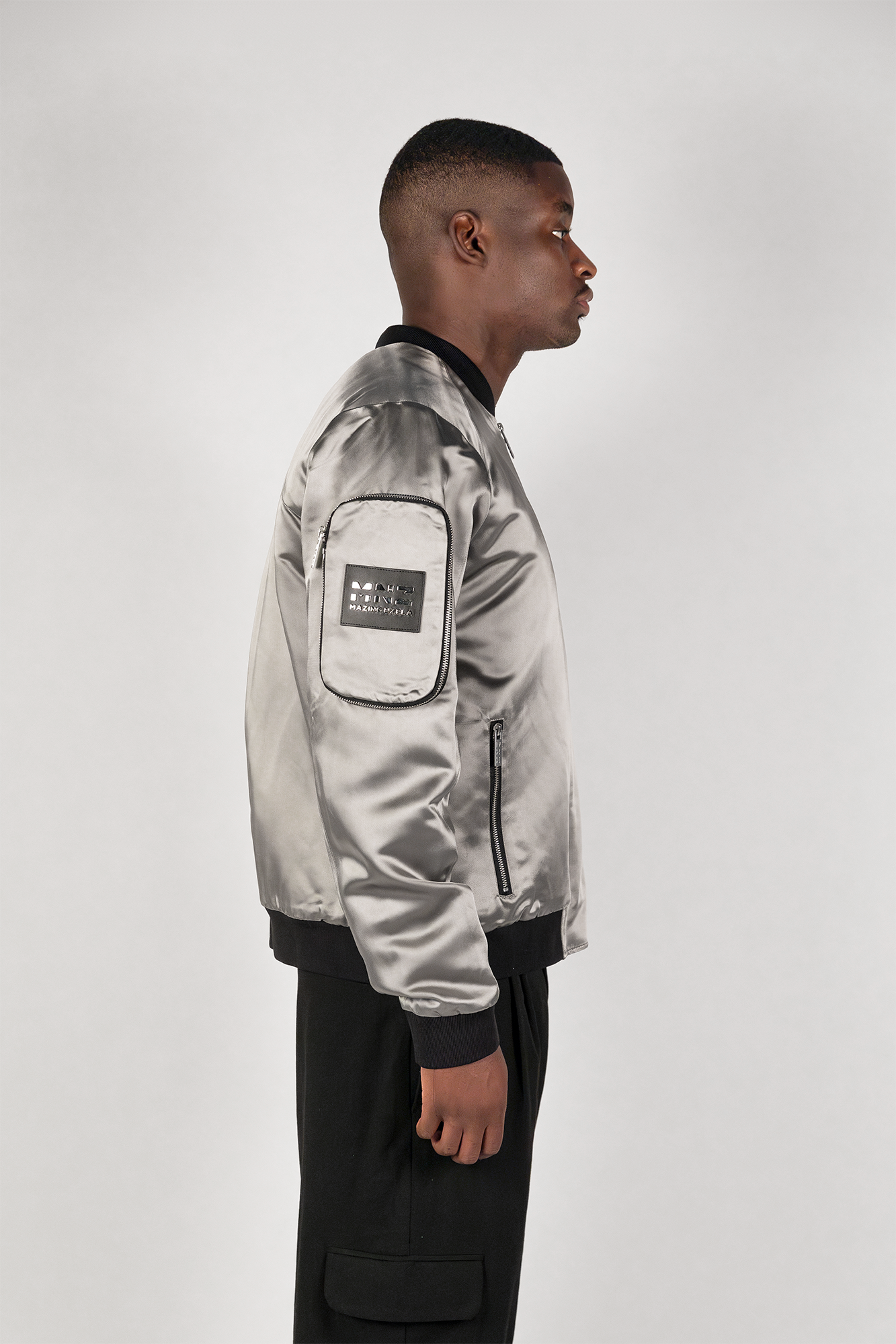 Men's bomber jacket with 3D cargo pockets, convertible crossbody bag, modular streetwear design, versatile and functional.